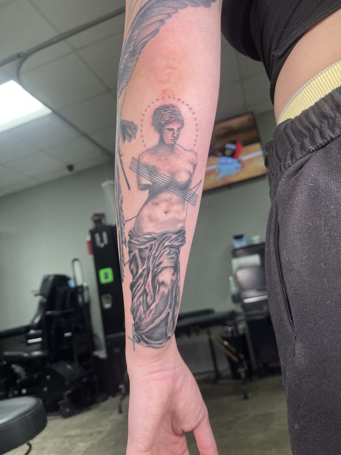Classical figure arm tattoo with architectural and illustrative elements