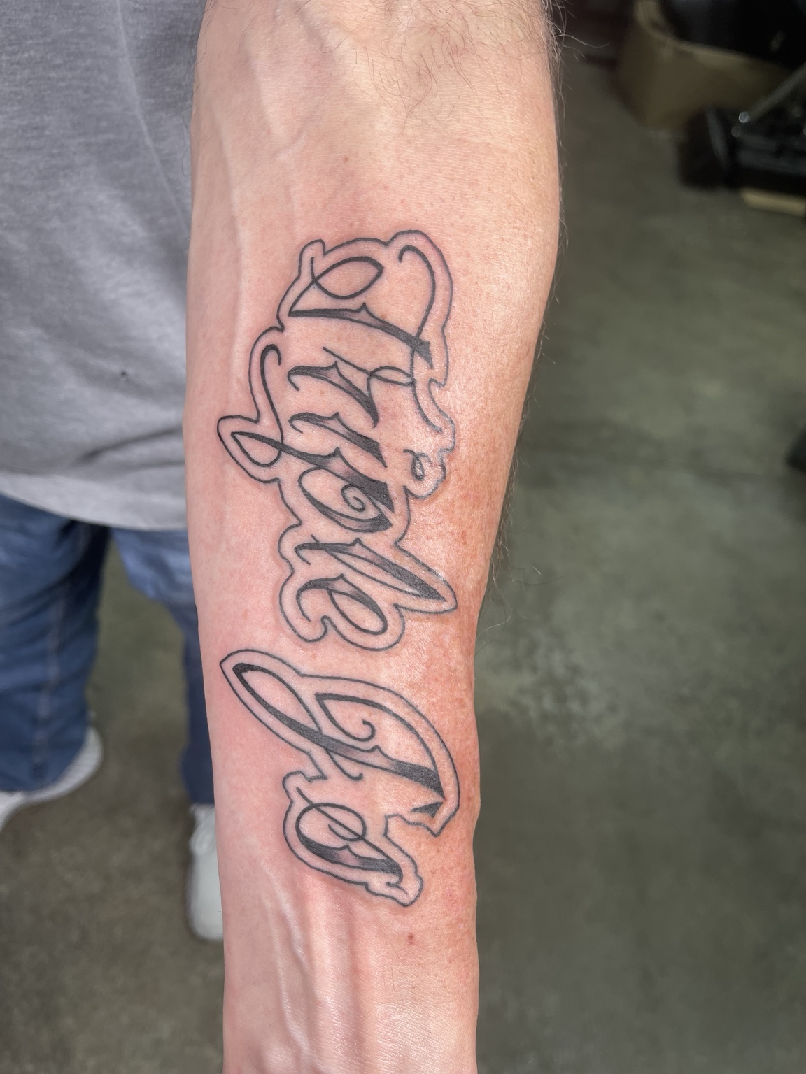 Large script forearm tattoo