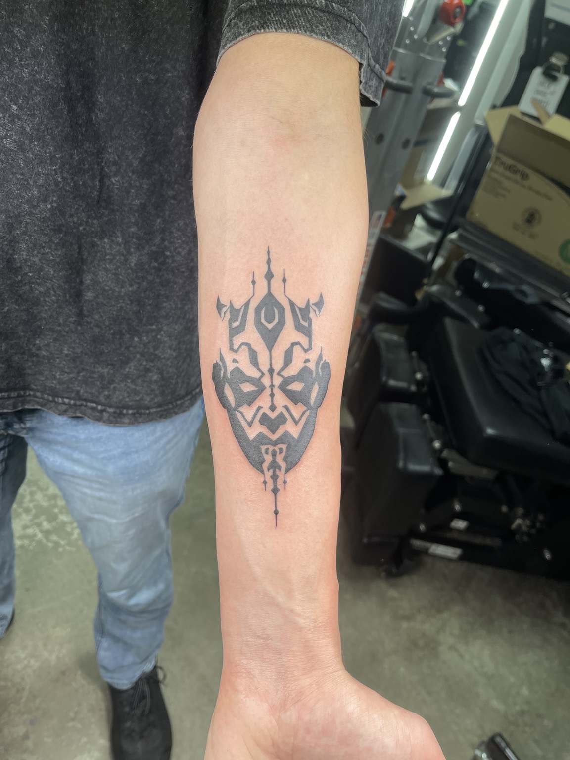 Black tribal-style forearm symbol tattoo