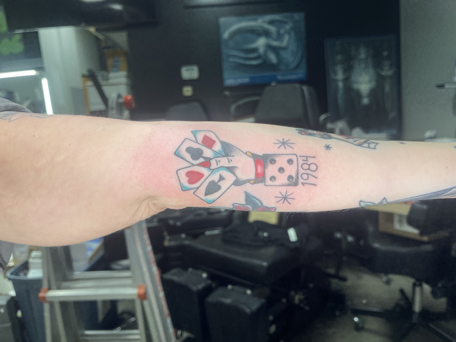 Playing-card and dice tattoo on forearm