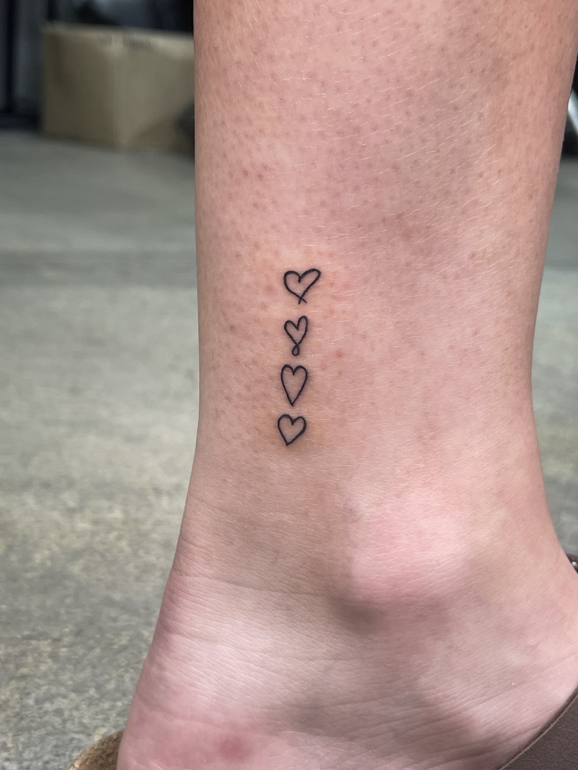 Three small outlined hearts tattoo