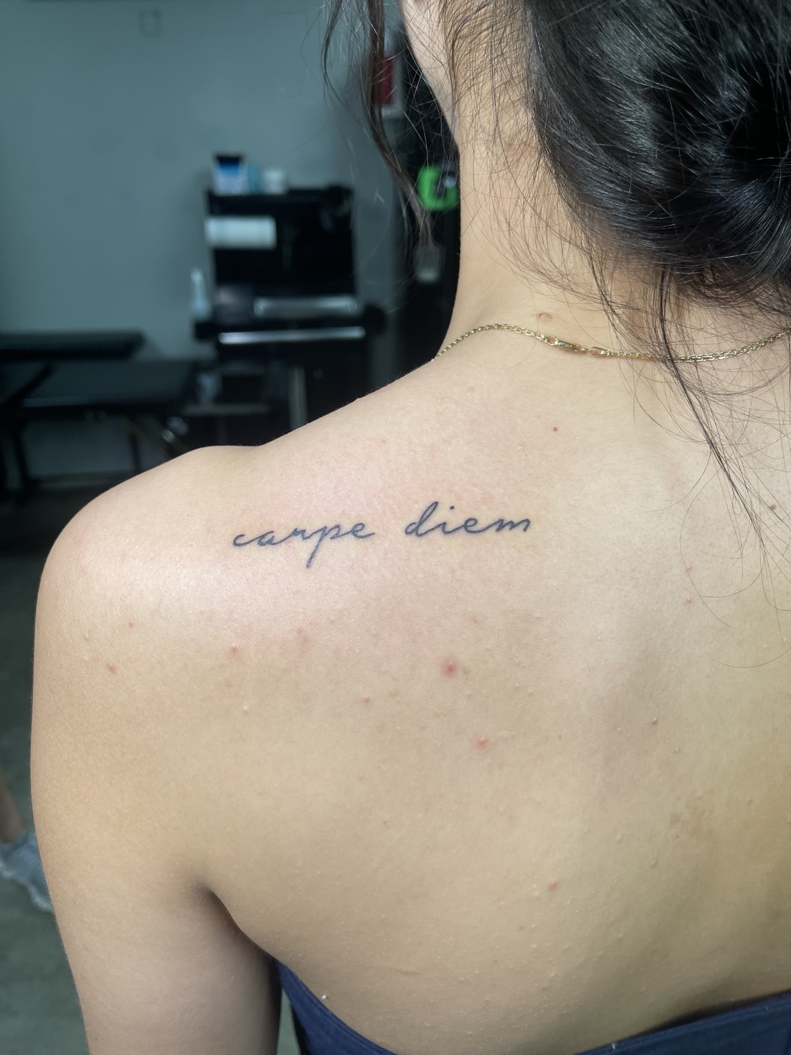 Small script tattoo near shoulder