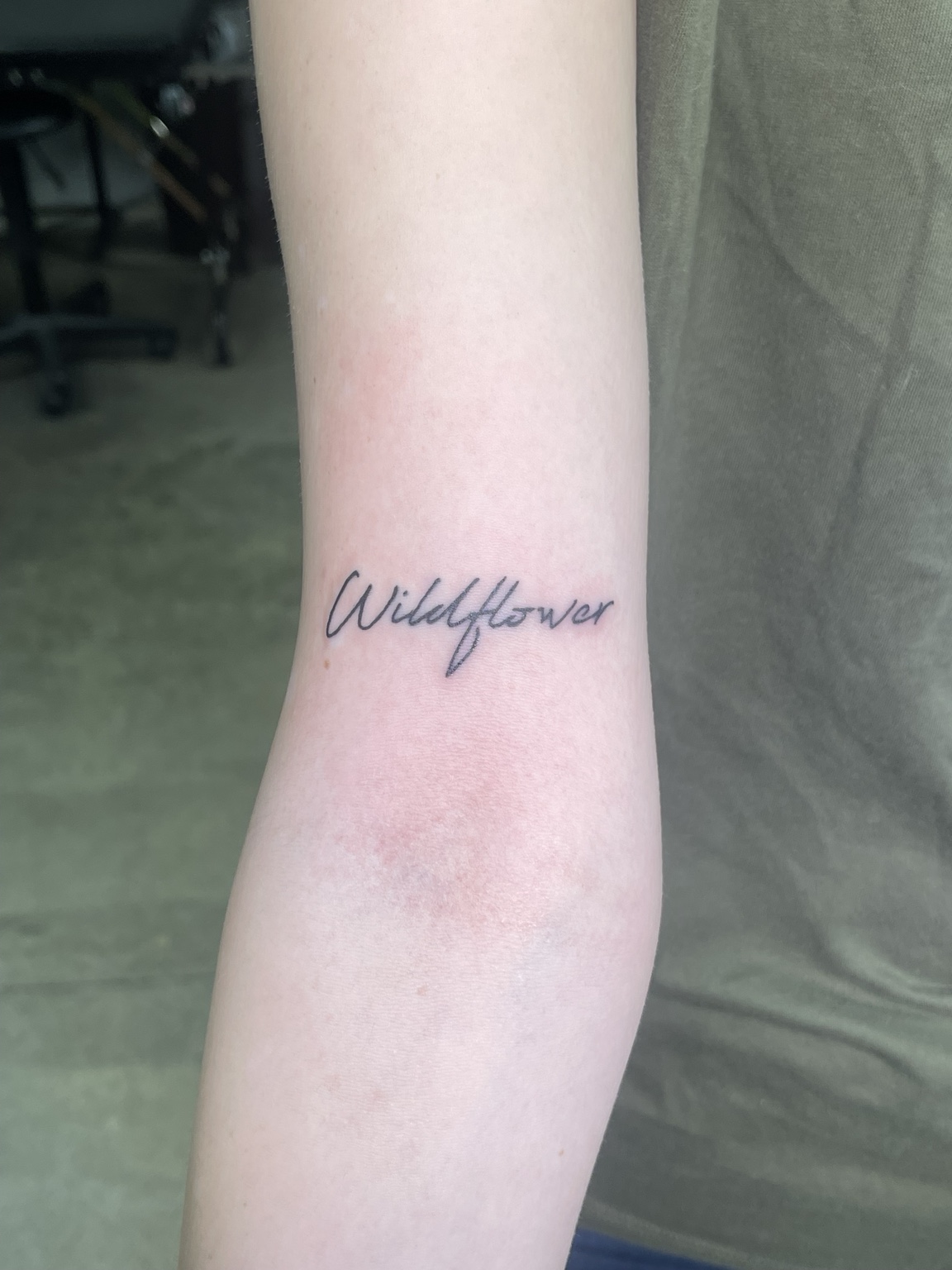 Small wildflower script tattoo on forearm