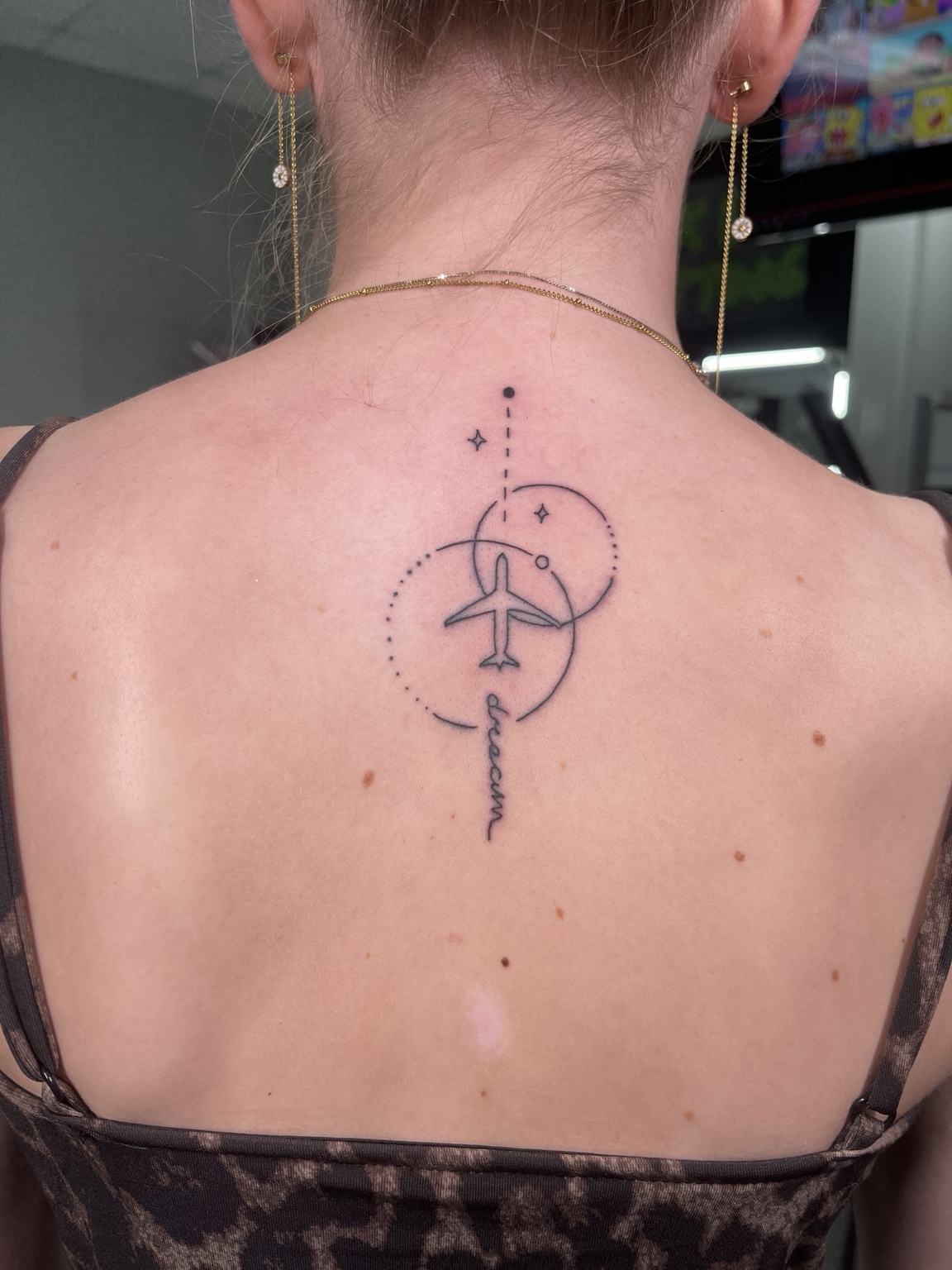 Minimal balance or yoga-inspired upper back symbol tattoo