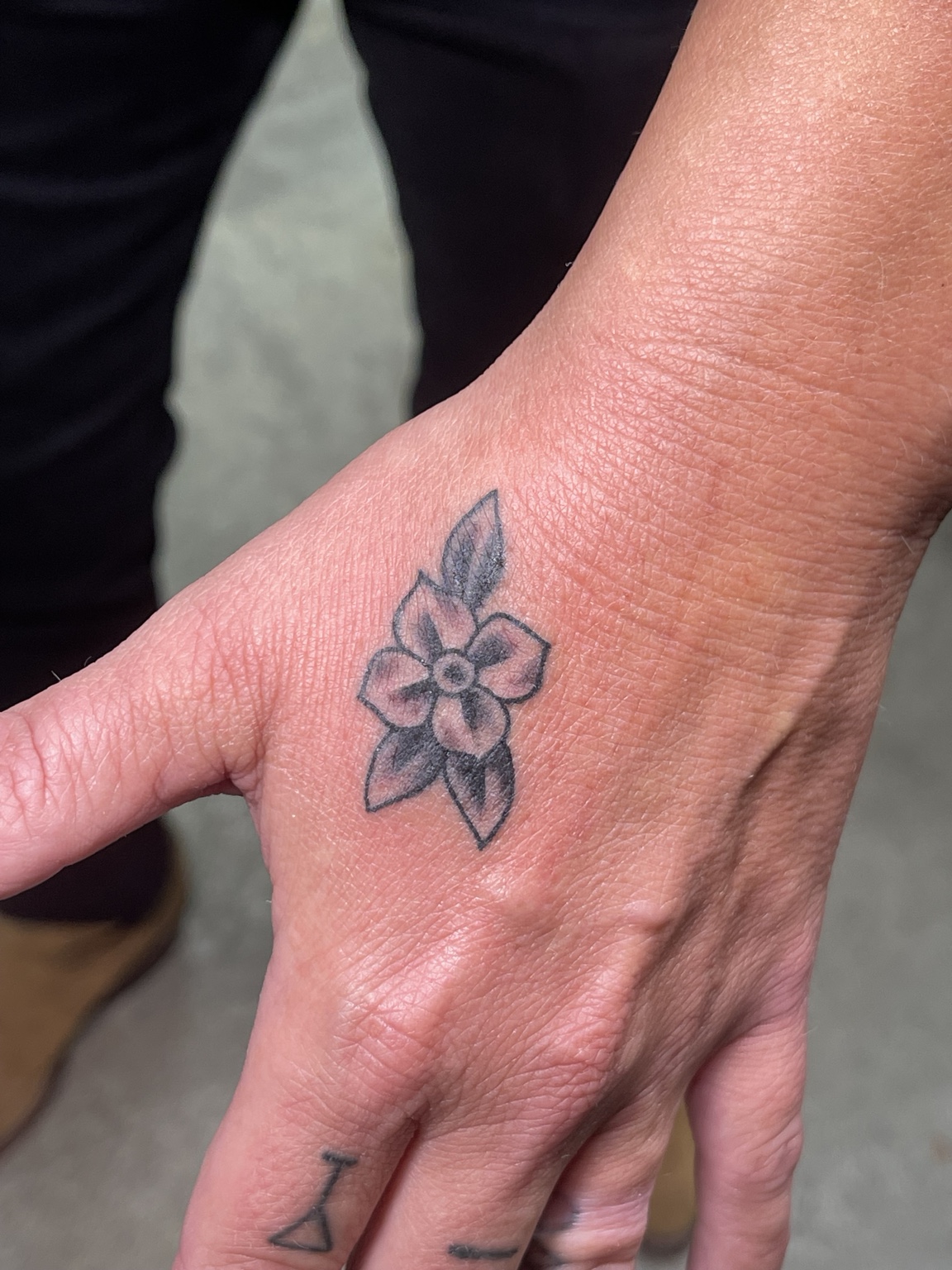 Small flower hand tattoo