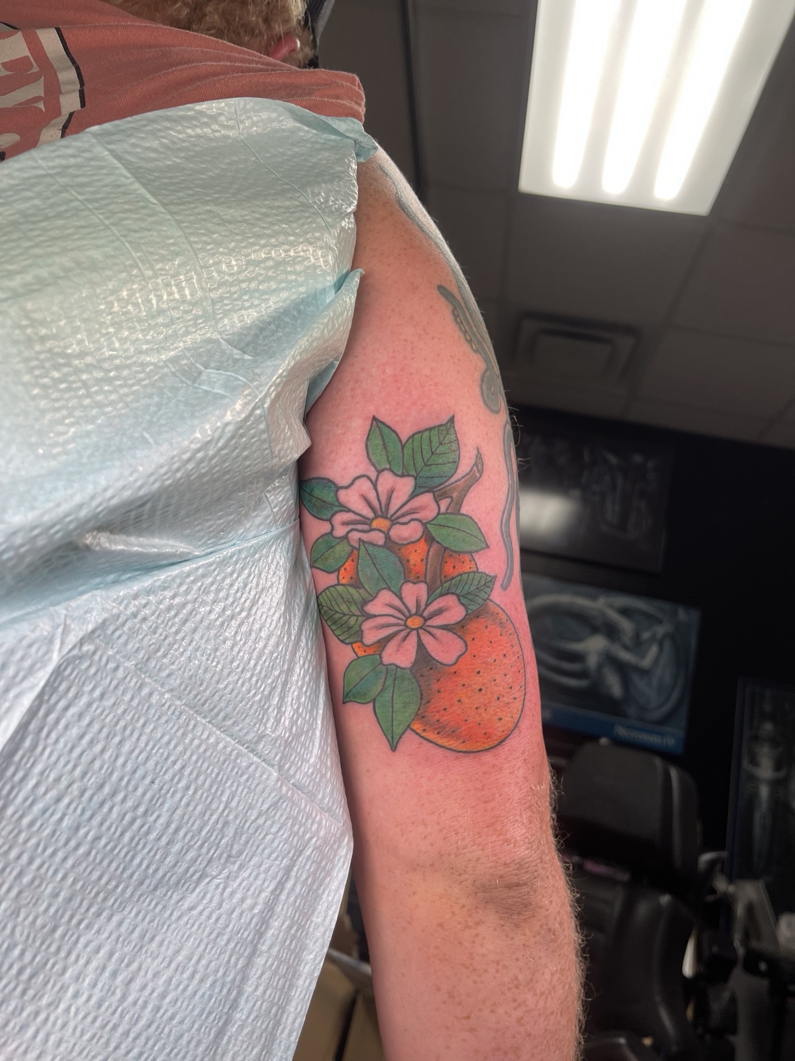 Red floral upper-arm tattoo