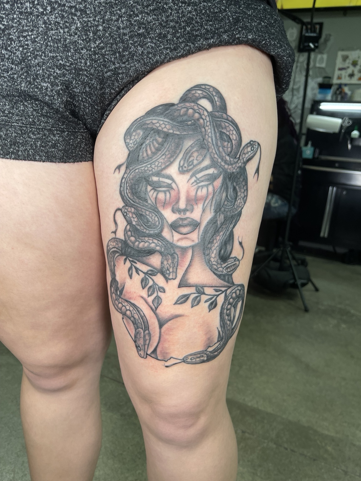 Completed black and grey Medusa thigh tattoo
