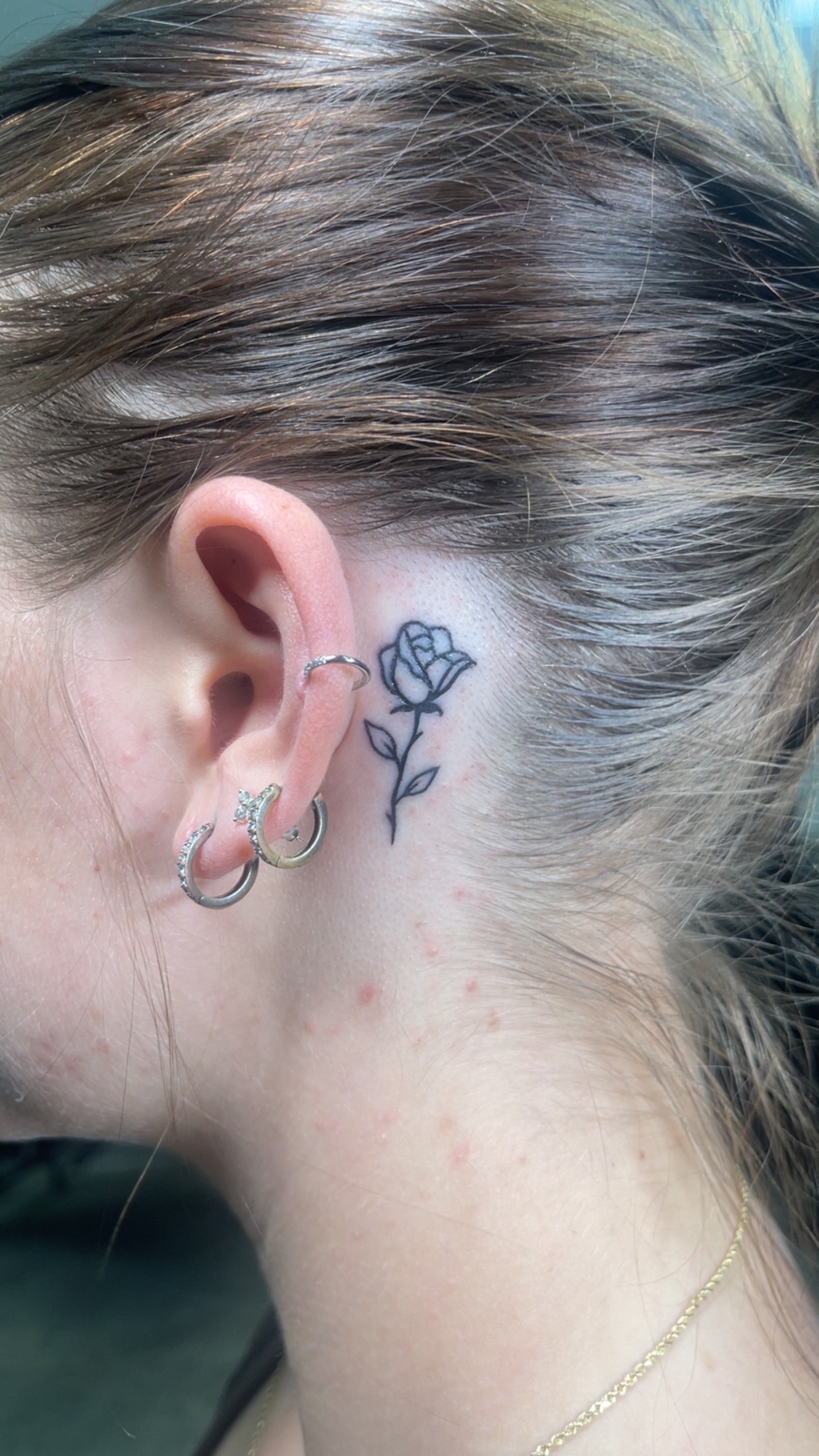 Tiny behind-ear line tattoo