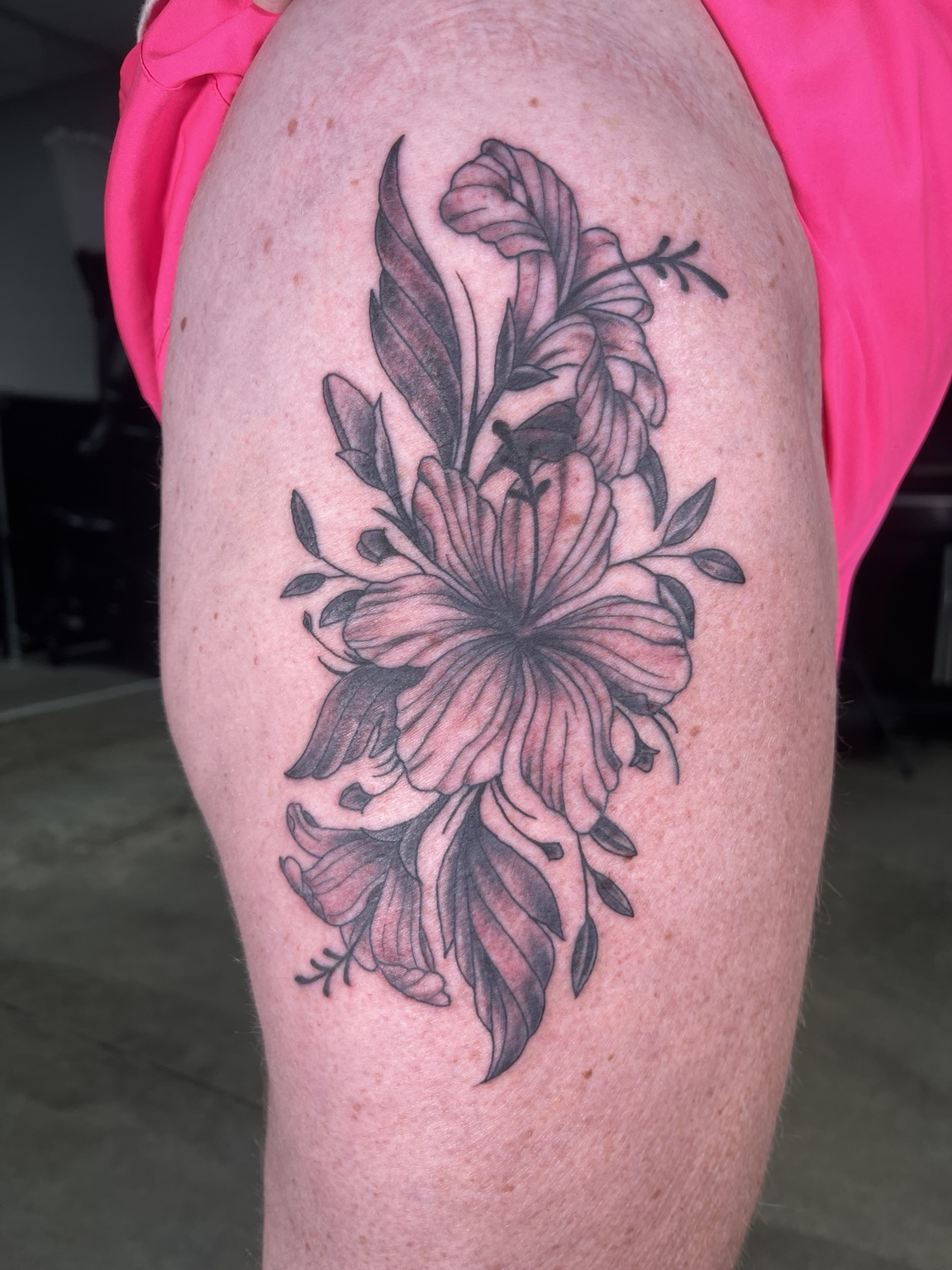 Dark floral thigh tattoo