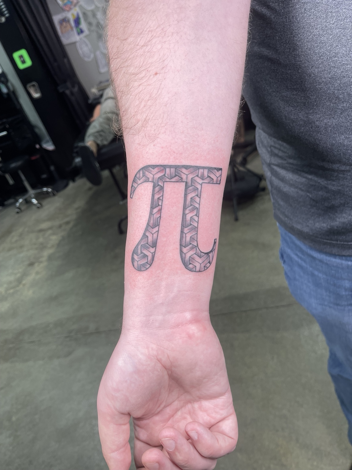 Pi symbol wrist tattoo