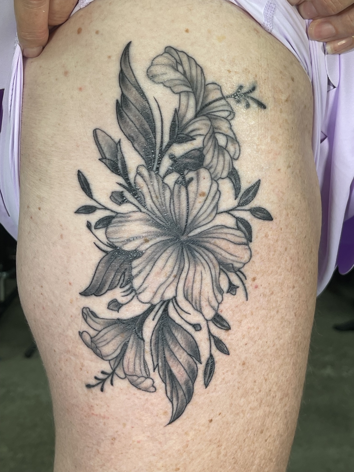 Black and grey floral thigh tattoo