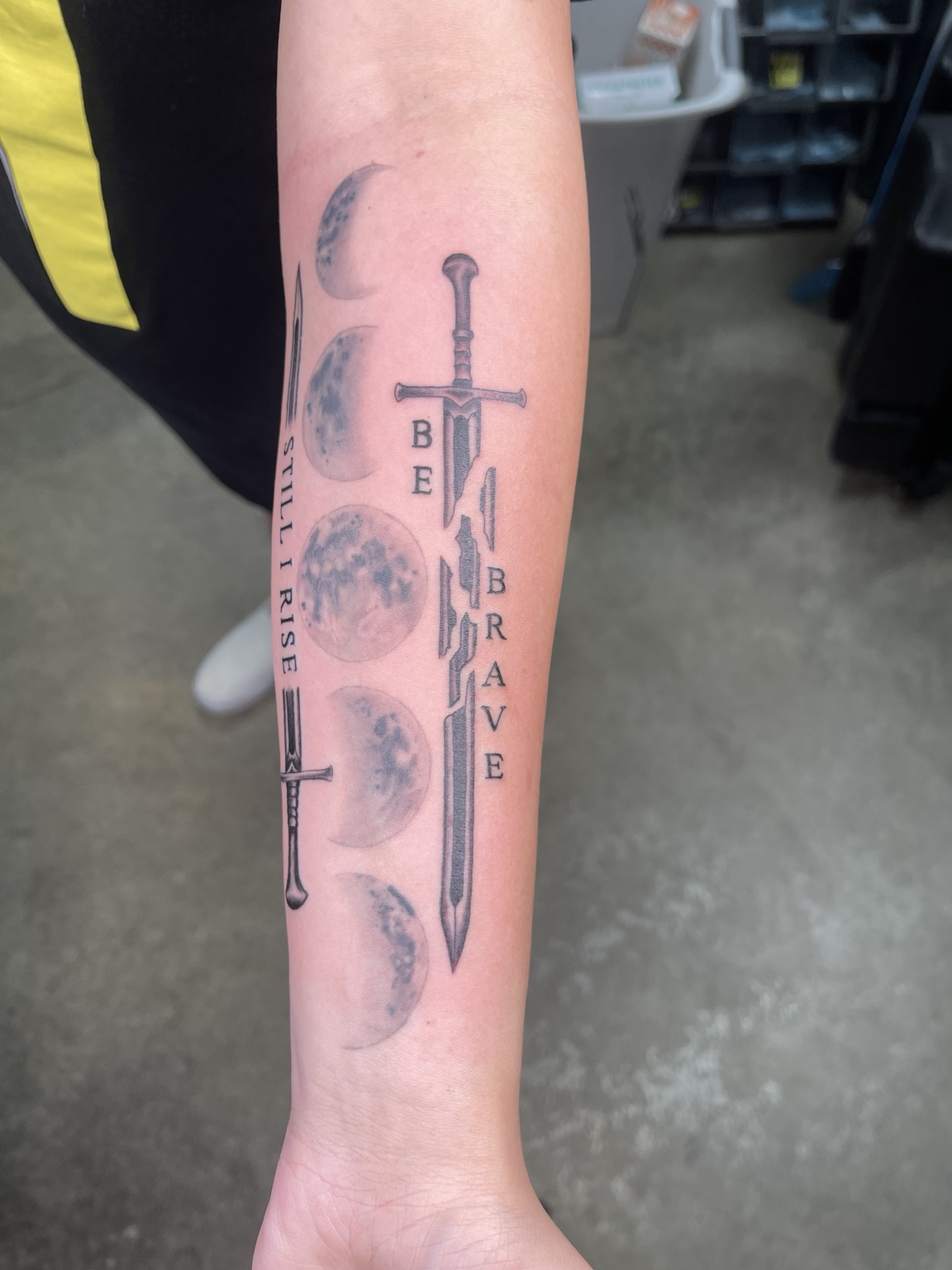 Sword and feather forearm tattoo primary view