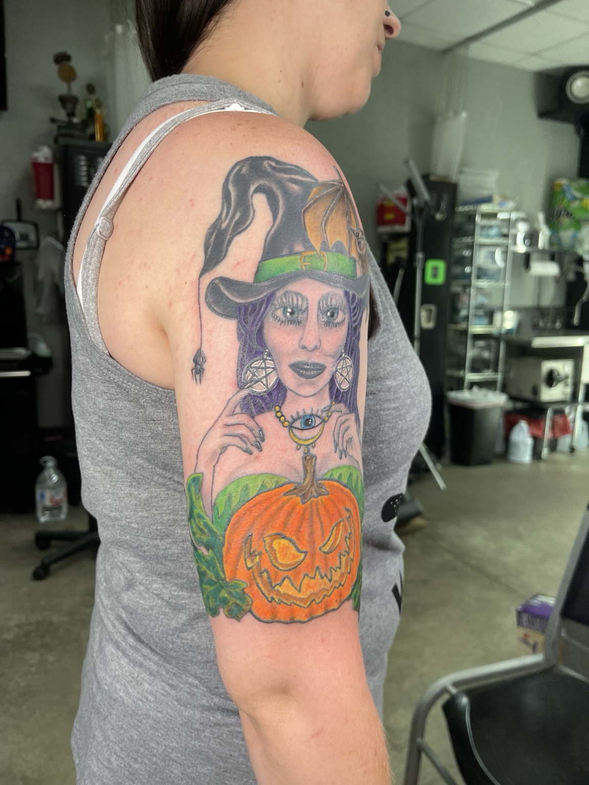 Witch and pumpkin upper arm tattoo