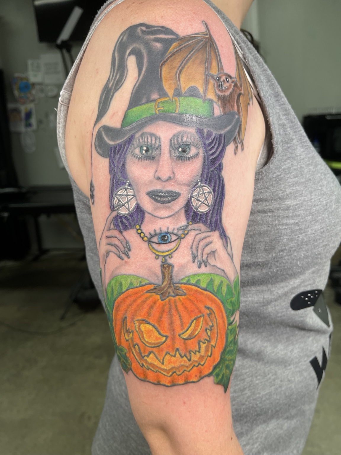 Completed witch and pumpkin upper-arm tattoo