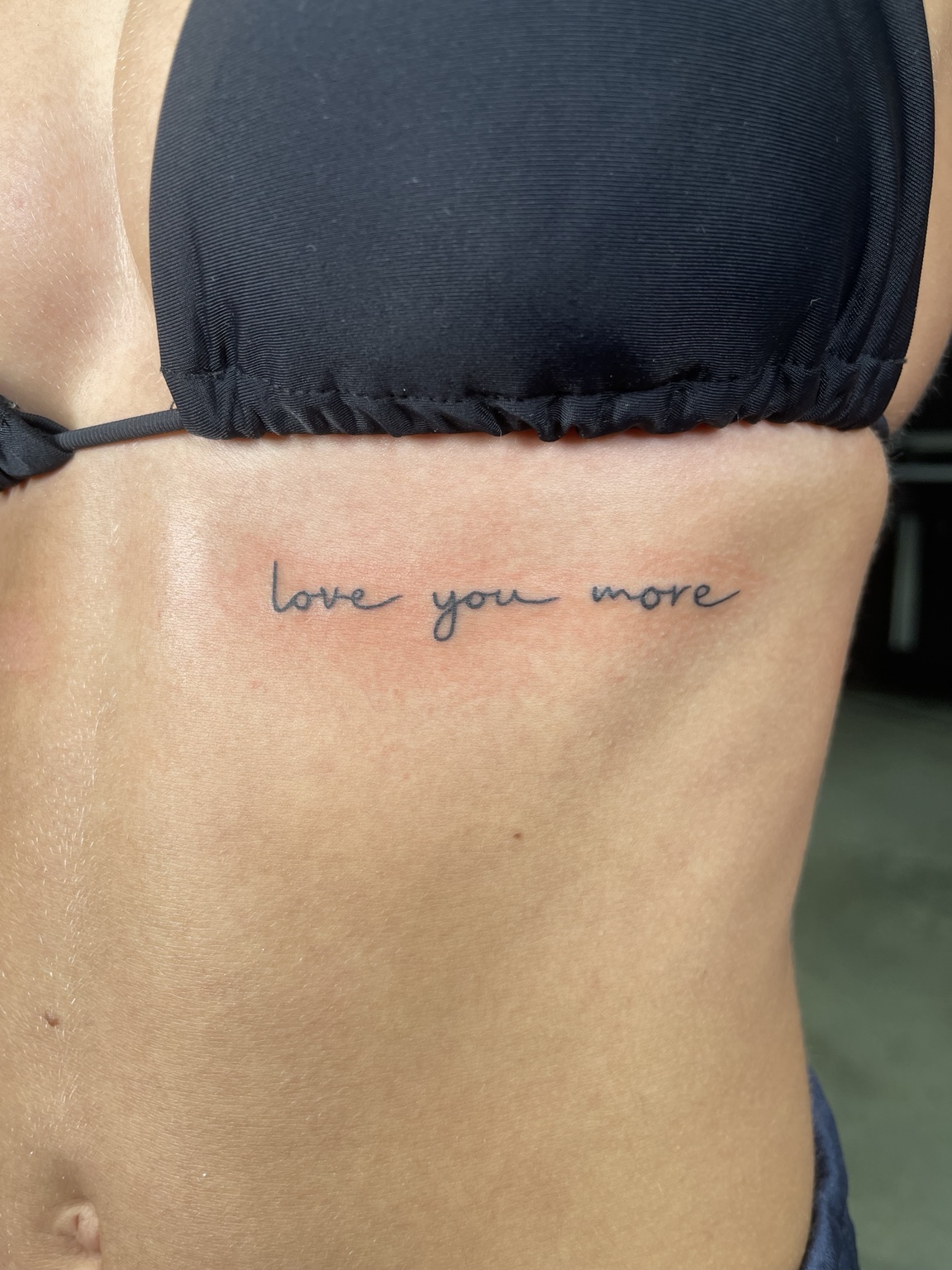 Small rib script tattoo