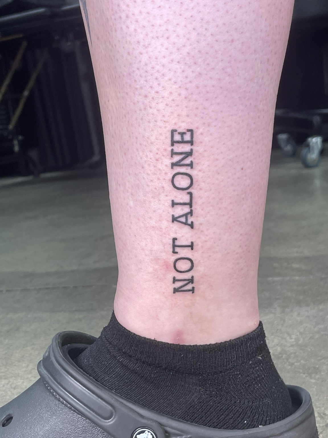 Not alone lettering tattoo