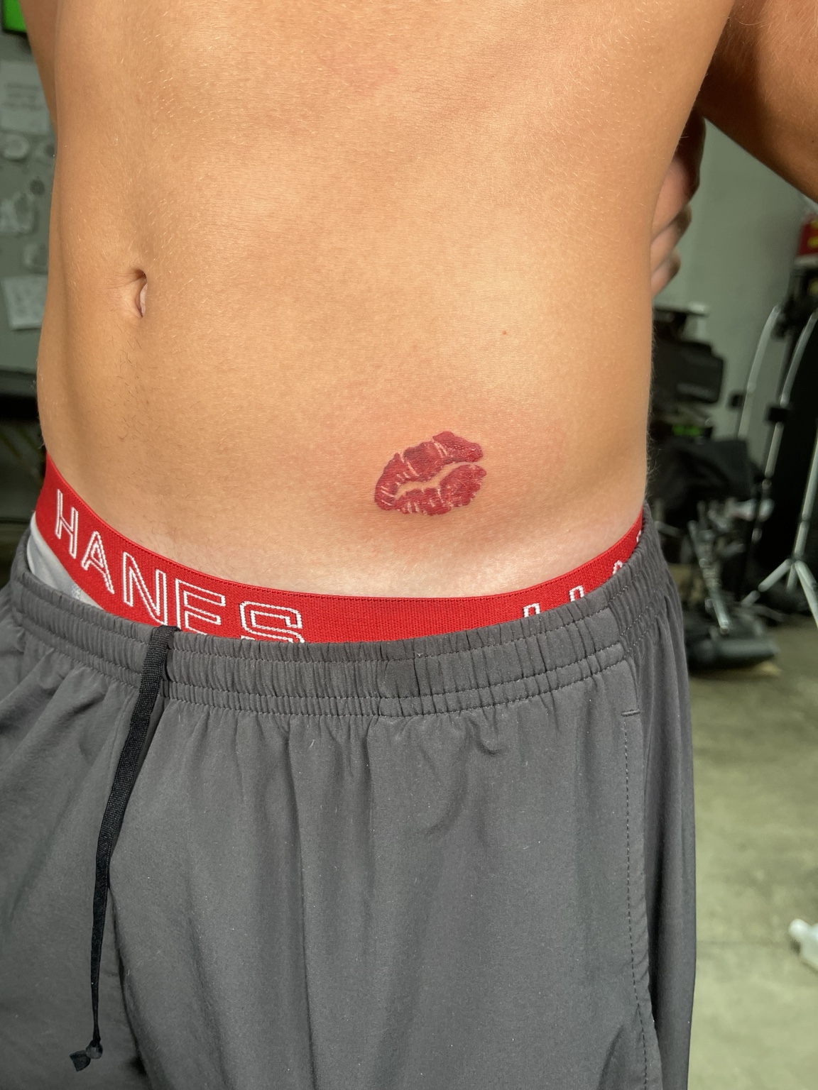 Small red lipstick kiss tattoo