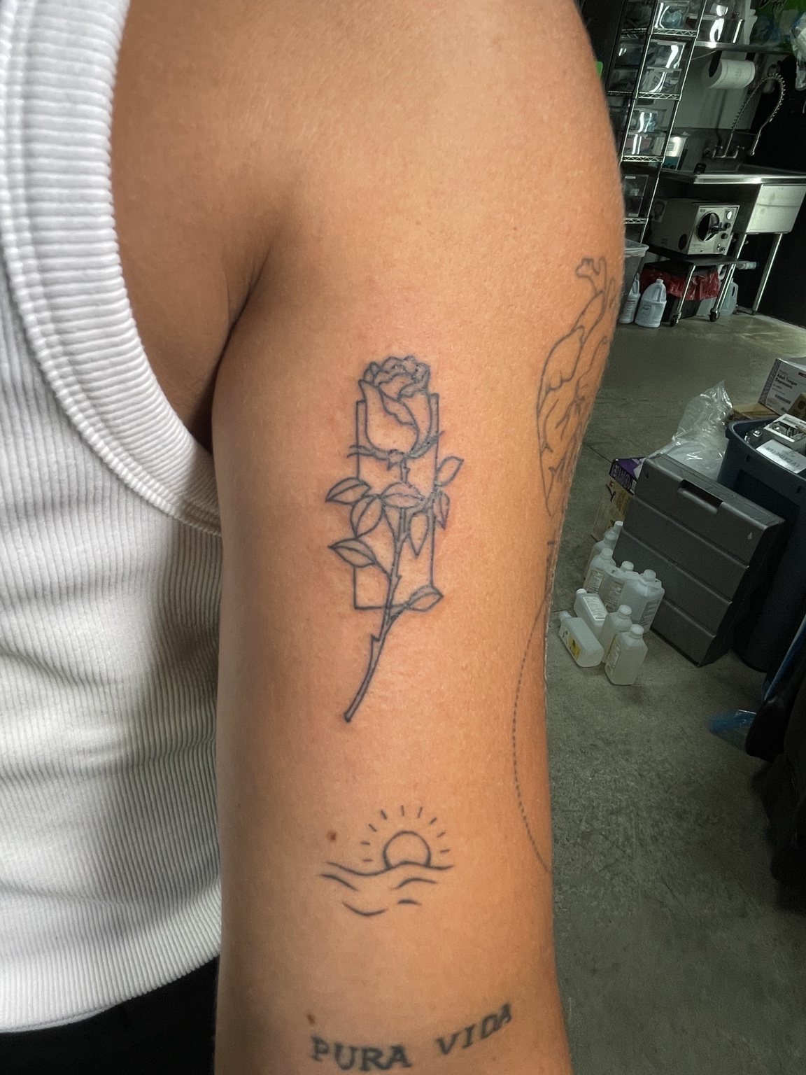 Fine-line rose with small sun tattoo